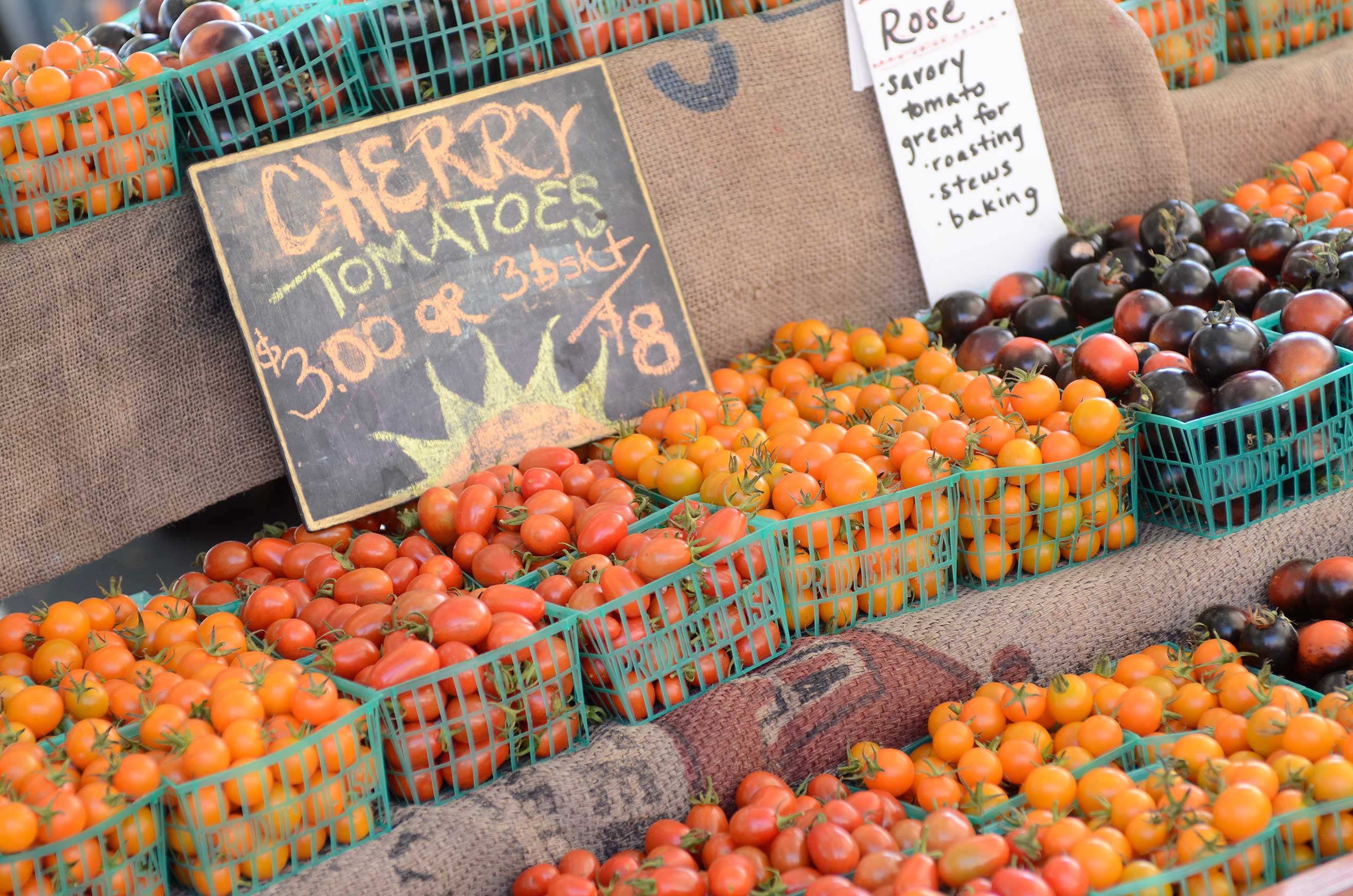 Plastic baskets of cherry tomatoes in orange, yellow, and dark purple varieties, for Honey Salt restaurant Summerlin Las Vegas.