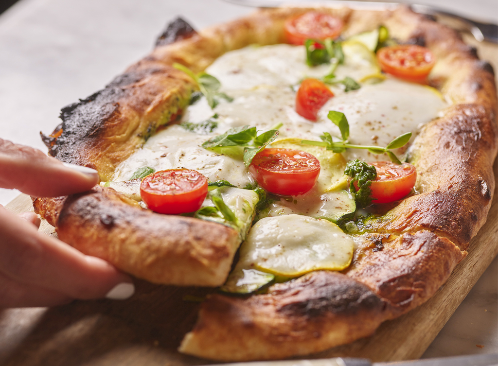 rustic pizza topped with melted mozzarella, cherry tomatoes, basil leaves, Honey Salt at a Summerlin restaurant in Las Vegas.
